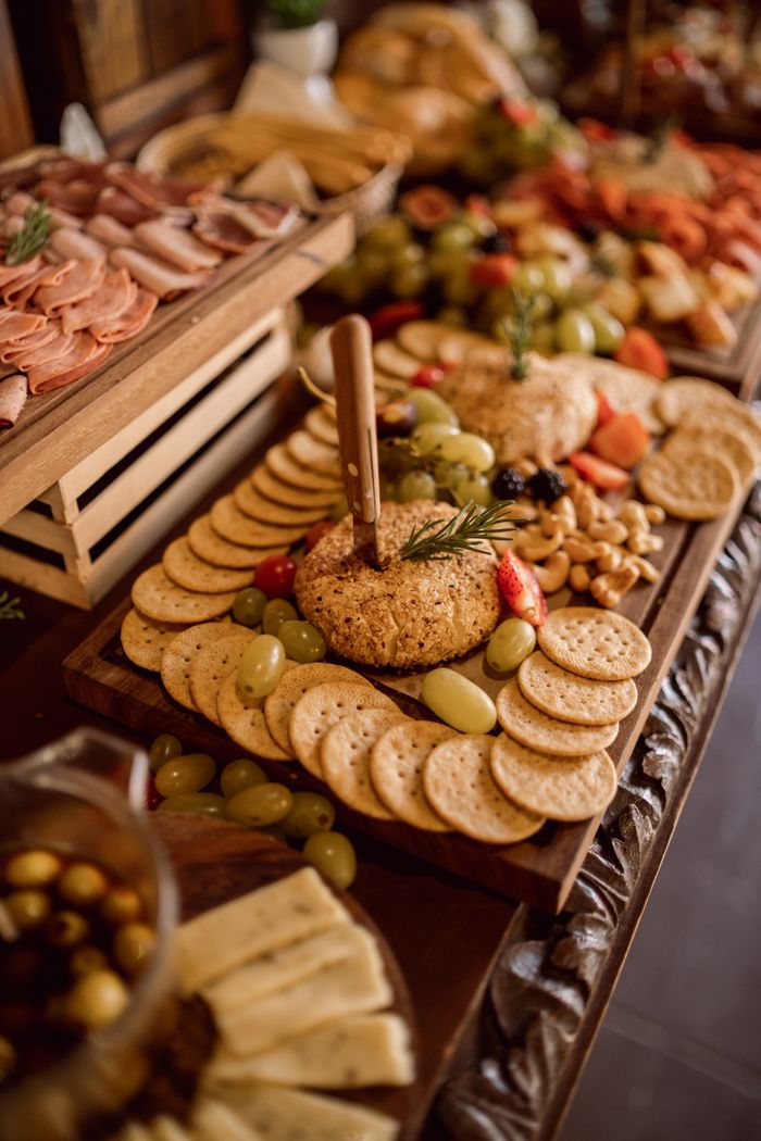 services-02 A beautifully arranged grazing table featuring cheeses, cold meats, fruits, and crackers.