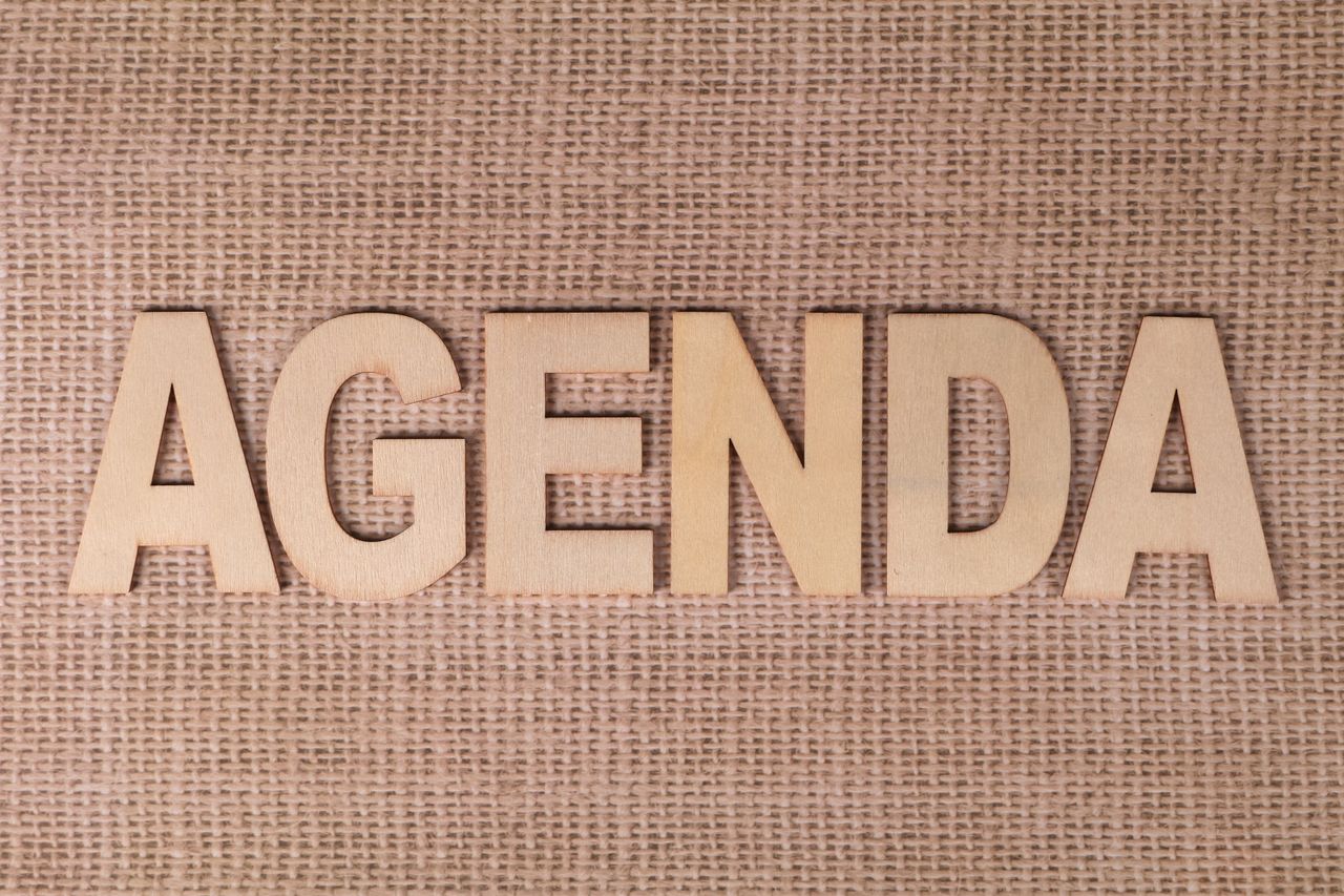 services-01 Wooden letters spelling 'AGENDA' on a textured burlap background.